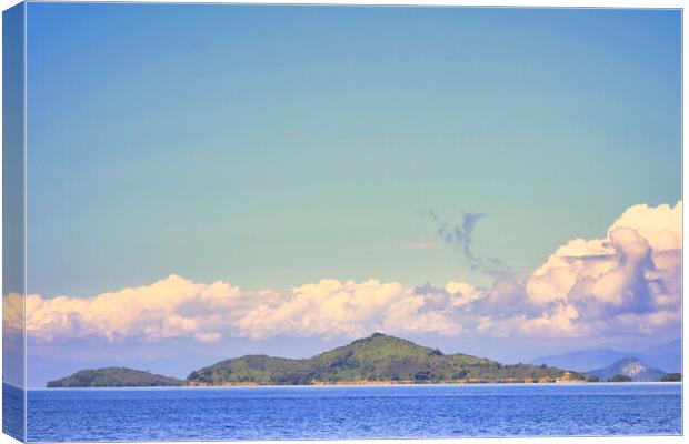 island with a clear blue sky background Canvas Print by John Lusikooy