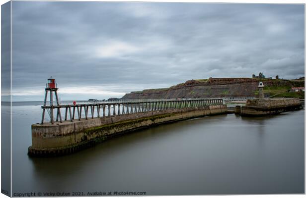 Whitby Pier with the lighthouse & Whitby Abbey in the distance.  Canvas Print by Vicky Outen