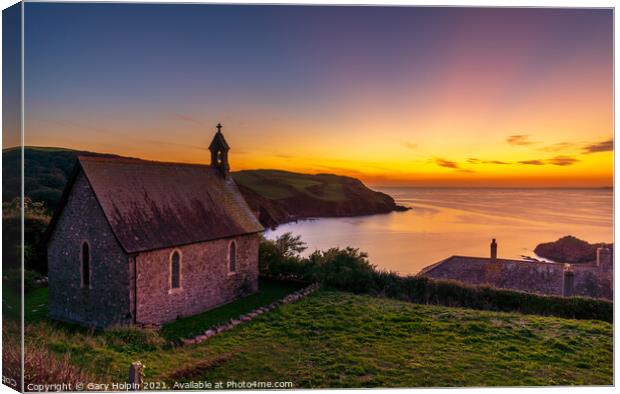 A sunset over the sea with a church in the foreground Canvas Print by Gary Holpin