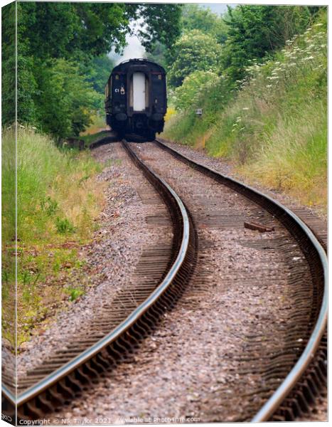 Train disappearing along the track Canvas Print by Nik Taylor