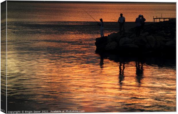 Silhouette of fishing people standing next to a bo Canvas Print by Engin Sezer
