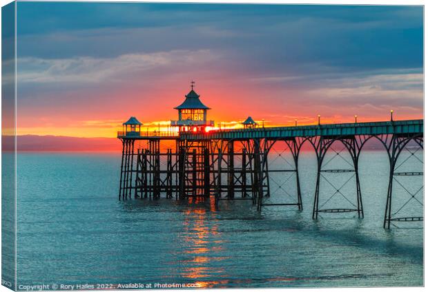 Clevedon Pier at sunset with a reddish orangey glow in the background Canvas Print by Rory Hailes
