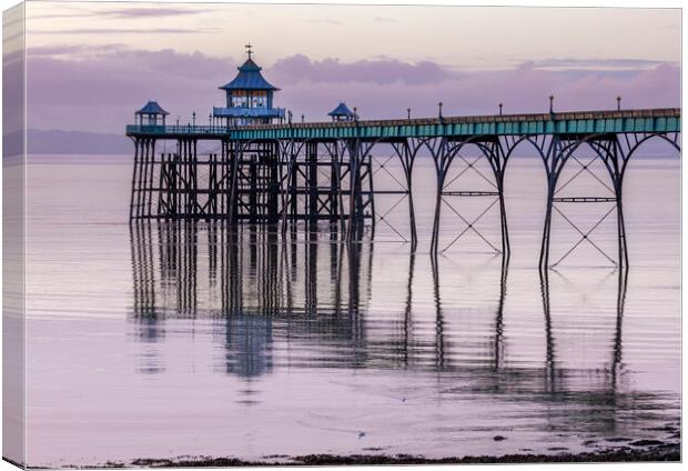 Clevedon Pier with its leg reflecting onto a calm sea Canvas Print by Rory Hailes
