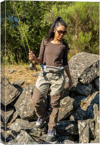 An asian women walking along a rocky river back while fly fishing in the summer Canvas Print by SnapT Photography