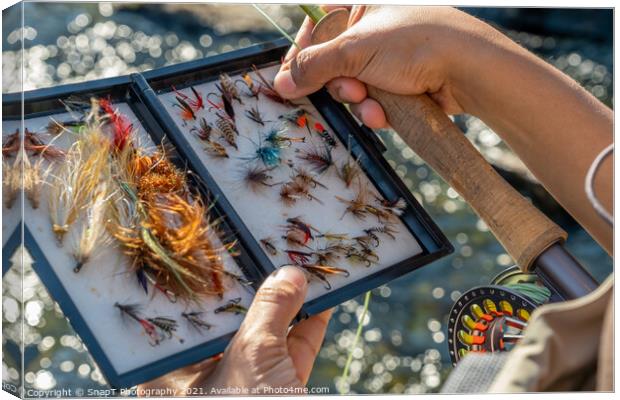 A close up of an asian female selecting fly fishing flies from a box Canvas Print by SnapT Photography