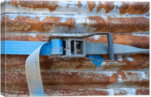 A blue rachet strap wrapped around a rusty corrugated iron metal sheet Canvas Print by SnapT Photography
