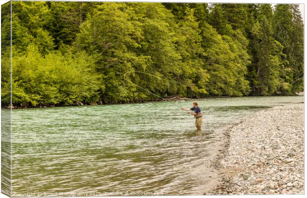 A fly fisherman spey casting, while wading in the fast flowing Kitimat River Canvas Print by SnapT Photography