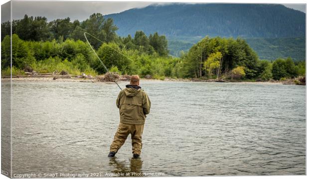 Fisherman battling a fish with a bent rod, while wading. Canvas Print by SnapT Photography