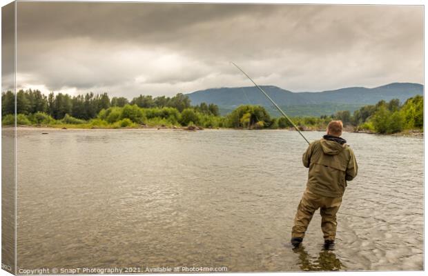 Fisherman battling a fish with a bent rod, while wading. Canvas Print by SnapT Photography