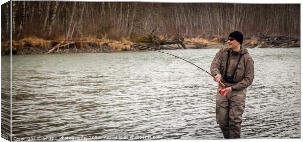 A fly fisherman hooked into a big fish in a river with the rod bent Canvas Print by SnapT Photography