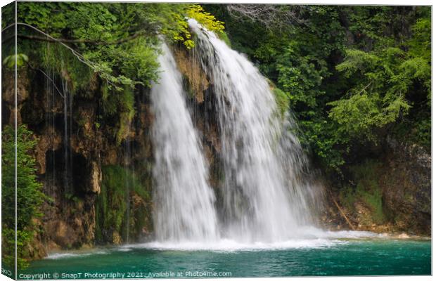 A waterfall flowing into a lake at Plitvice Lakes, Unesco world heritage site Canvas Print by SnapT Photography