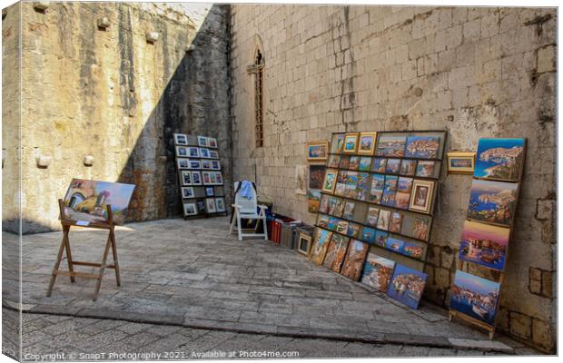 An artists stall in Dubrovnik's old town in a late summers afternoon, Croatia Canvas Print by SnapT Photography