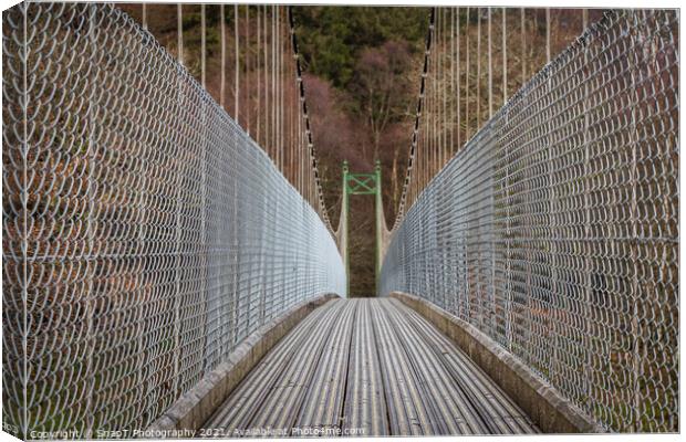 View across a wooden suspension bridge leading into a forest woodland Canvas Print by SnapT Photography