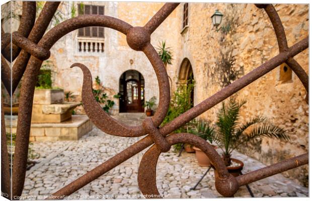 Ornamental iron gate with view into a mediterranea Canvas Print by MallorcaScape Images
