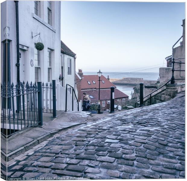 Whitby town cobbled streets and sea view Canvas Print by Stuart Chard
