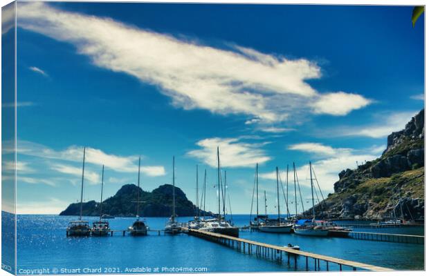 Bay with boats on a jetty Canvas Print by Stuart Chard