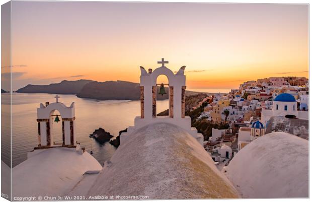 Blue domed churches and bell tower facing Aegean Sea with warm sunset light in Oia, Santorini, Greece Canvas Print by Chun Ju Wu