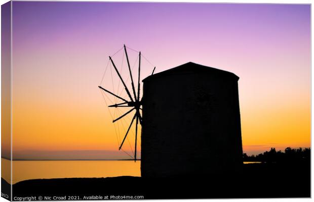 Silhouette of a Greek windmill at sunset Canvas Print by Nic Croad