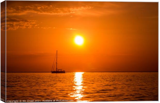 Yacht on the sea at sunset Canvas Print by Nic Croad
