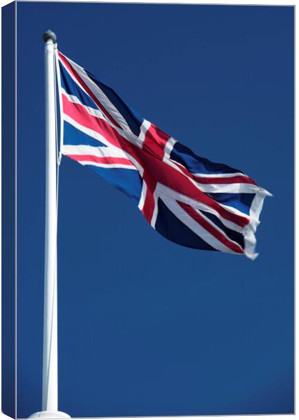 Union Jack flying against blue sky Canvas Print by Neil Overy