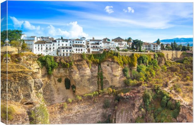 Famous Ronda restaurants and colonial houses overlooking the scenic gorge and the Puente Nuevo bridge Canvas Print by Elijah Lovkoff