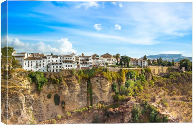 Famous Ronda restaurants and colonial houses overlooking the scenic gorge and the Puente Nuevo bridge Canvas Print by Elijah Lovkoff