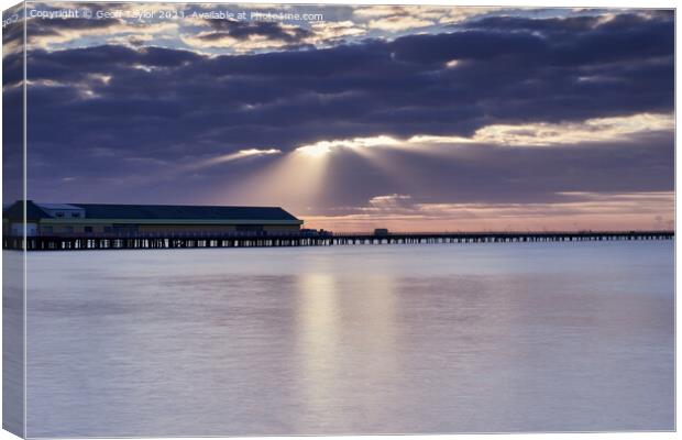 Rays over the pier Canvas Print by Geoff Taylor