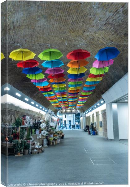 An array of colourful umbrellas at London Bridge Station. Canvas Print by johnseanphotography 