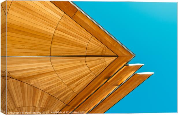Abstract view of roof structure against blue sky.  Canvas Print by Paul Tuckley