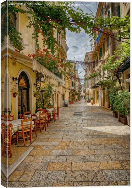Shaded street in Corfu Town Canvas Print by John Gilham