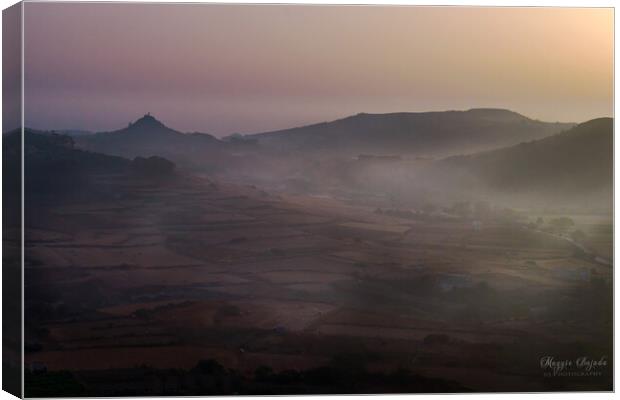 Early morning sunrise with mist all over the fields in Gozo, Malta.  Canvas Print by Maggie Bajada