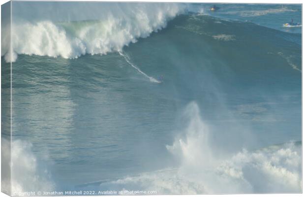 Surfer on a XXL wave at Nazare Portugal Canvas Print by Jonathan Mitchell