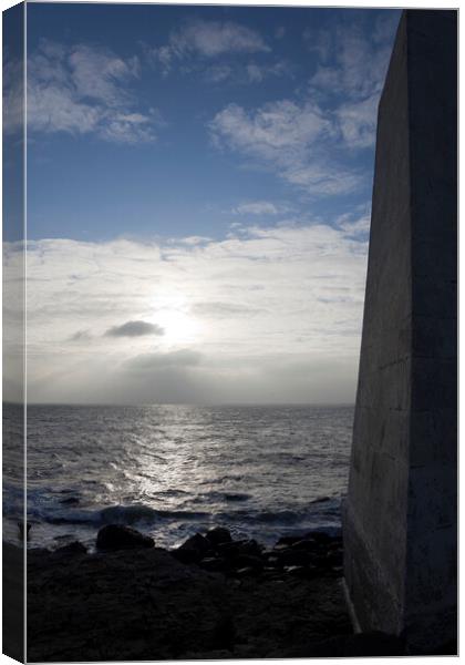 A dark obelisk looks over the sea at Portland Bill Dorset towards the setting sun Canvas Print by Gordon Dixon