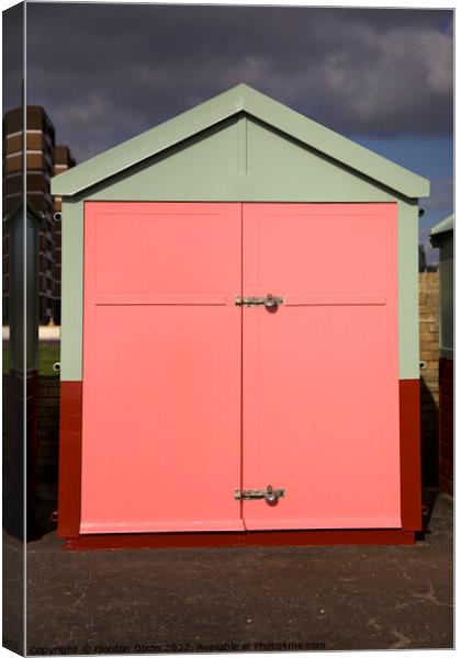 Peach colour beach hut against stormy sky Canvas Print by Gordon Dixon