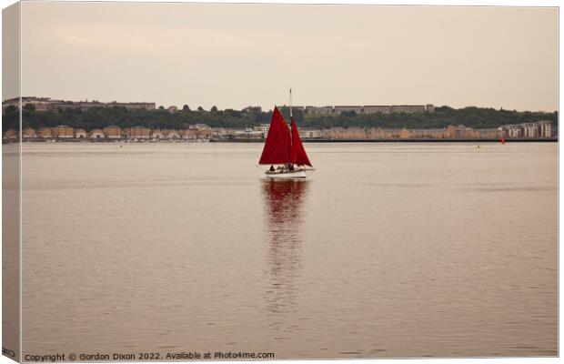 Yacht with red sails set approaches Cardiff Bay, South Wales Canvas Print by Gordon Dixon