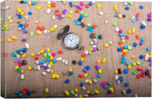 Pocket watch amid Colorful pebbles  Canvas Print by Turgay Koca