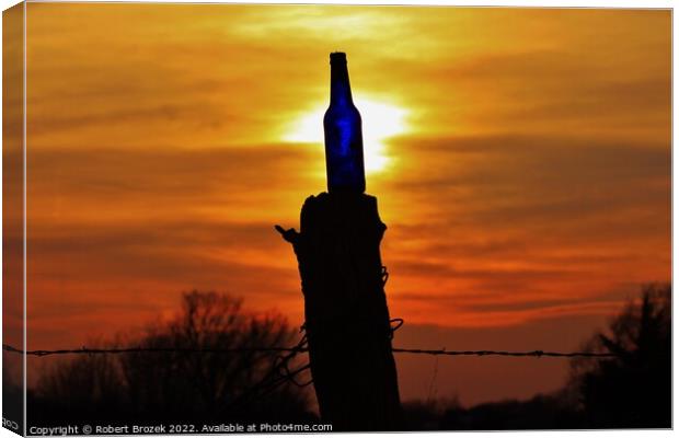 Sunset with a bottle on a fence post with sky. Canvas Print by Robert Brozek