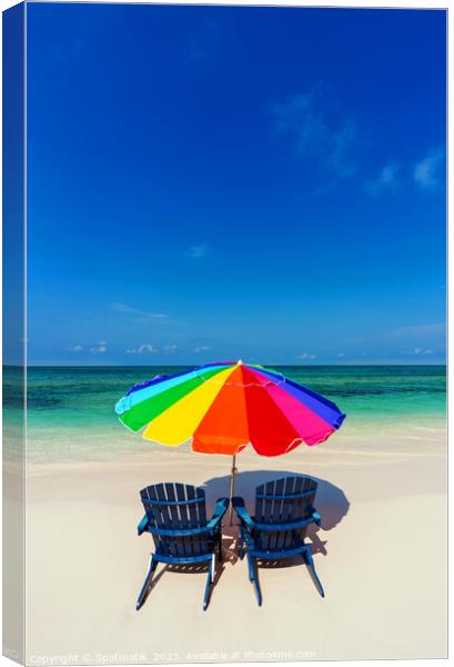 Bahamas beach umbrella and chairs on sandy beach  Canvas Print by Spotmatik 