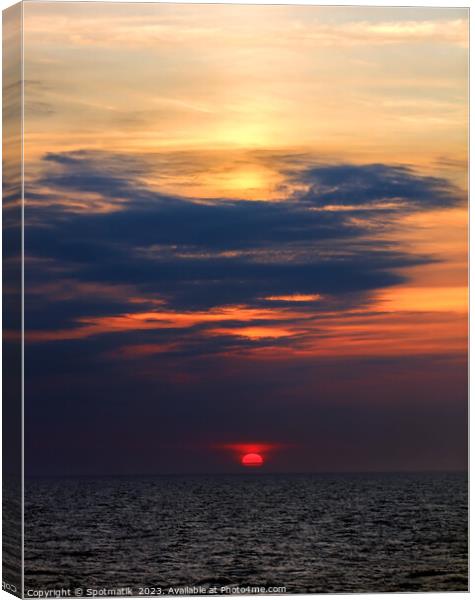 Sunset dusk view of setting sun ocean horizon  Canvas Print by Spotmatik 
