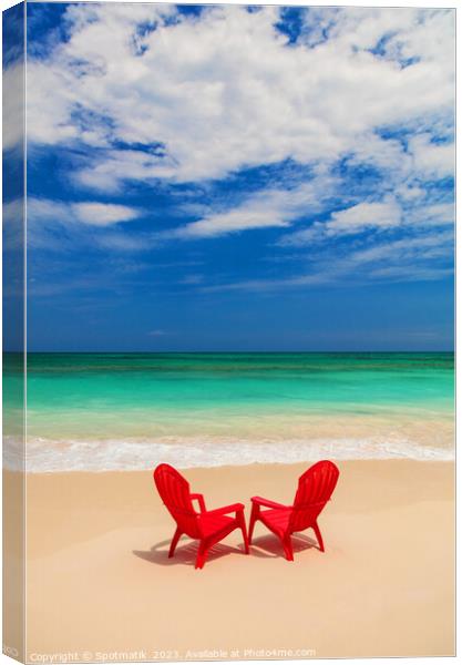 Red chairs on sandy beach by ocean Bahamas Canvas Print by Spotmatik 