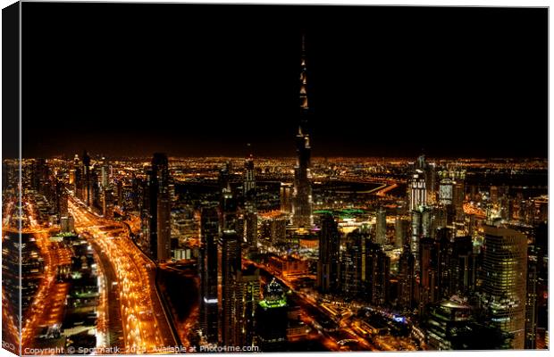 Aerial Dubai illuminated night view of Burj Khalifa  Canvas Print by Spotmatik 