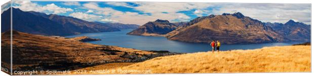 Panorama of New Zealand trekking couple viewing Lake Wakatipu Canvas Print by Spotmatik 