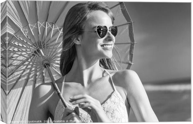 Smiling American hippy chic with parasol on beach Canvas Print by Spotmatik 