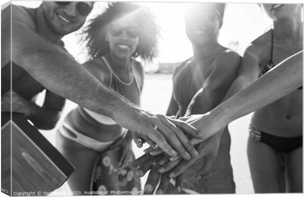Friends in swimwear joining hands on beach vacation Canvas Print by Spotmatik 