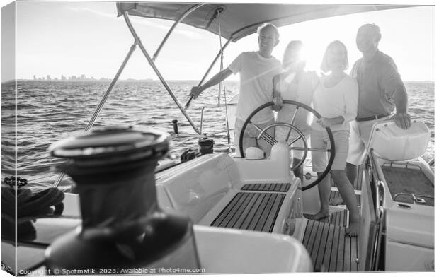 Senior friends enjoying retirement steering yacht at sunset Canvas Print by Spotmatik 