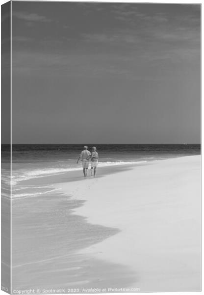 Tropical island shoreline with retired couple walking barefoot Canvas Print by Spotmatik 