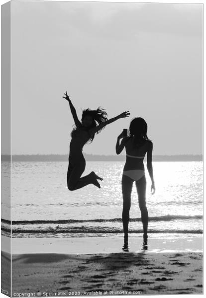 Tropical ocean sunrise with girl photographing friend jumping Canvas Print by Spotmatik 