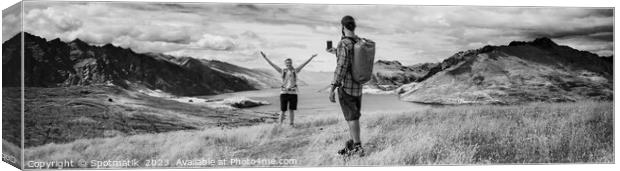 Panorama of young backpacking couple taking smartphone picture Canvas Print by Spotmatik 