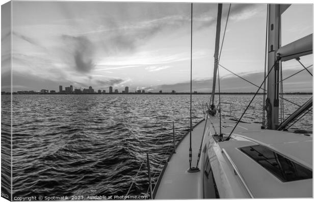 Yacht sailing towards cityscape on horizon at sunset Canvas Print by Spotmatik 