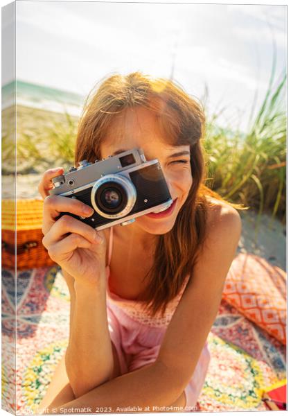 Smiling Caucasian girl with camera photographing beach vacation Canvas Print by Spotmatik 